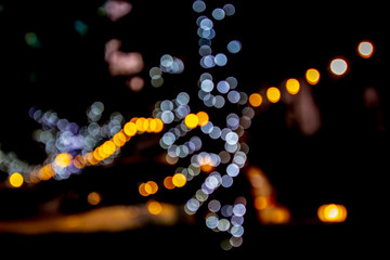 Beautiful bokeh from light on the tree at garden park and car.