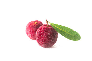 A few bayberries with a green leaf on a white background