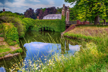 The house next to the brook and the bridge is a funny mirror as a mouth in the water
