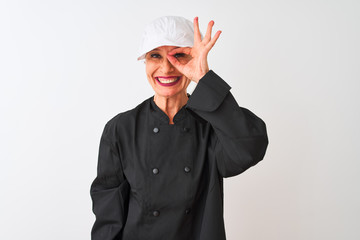 Middle age chef woman wearing uniform and cap standing over isolated white background doing ok gesture with hand smiling, eye looking through fingers with happy face.