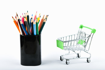 Office Tools In A Shopping Cart. Online shopping concept. Cart and pencils over a white background.