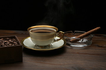 cup of hot coffee and cigar on wooden background with copy space