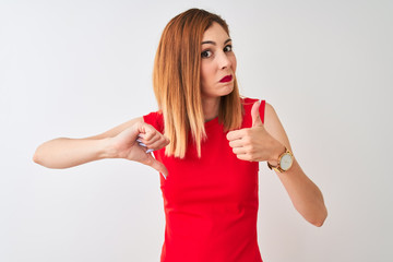Redhead businesswoman wearing elegant red dress standing over isolated white background Doing thumbs up and down, disagreement and agreement expression. Crazy conflict