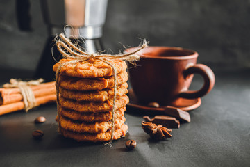 Homemade cookies and brown cup with coffee on dark background