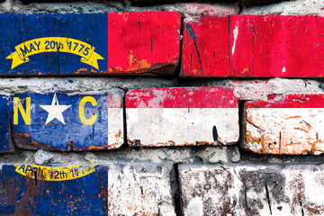 North Carolina grunge, damaged, scratch, old style united states flag on brick wall.