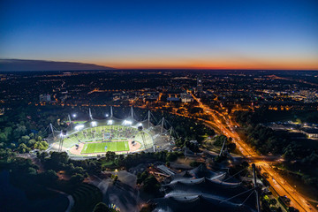 Nächtlicher Blick über München, den Olympiapark und das erleuchtete Olympiastadion - obrazy, fototapety, plakaty