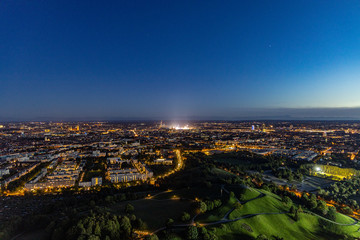 Fototapeta na wymiar Abendlicher Panoramablick über München mti dem hell erleuchteten Oktoberfest