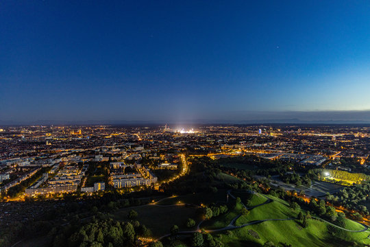 Abendlicher Panoramablick &uuml;ber M&uuml;nchen mti dem hell erleuchteten Oktoberfest