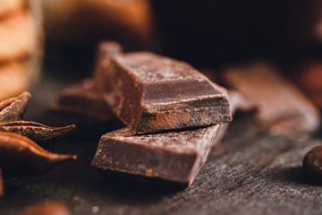 Chopped dark chocolate cubes on wooden board, close-up view