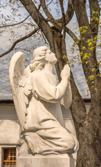 Ancient sculpture of  praying angel in white marble