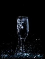 splash and spatter of water in a wine glass on a black background