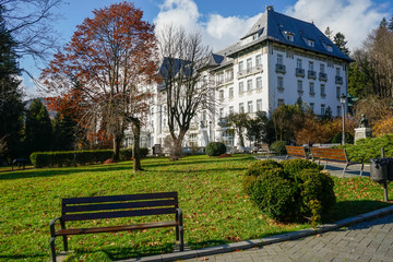 Autumn scenery in the central park of Sinaia City , Romania with representative architecture buildings , alleys and decorative trees