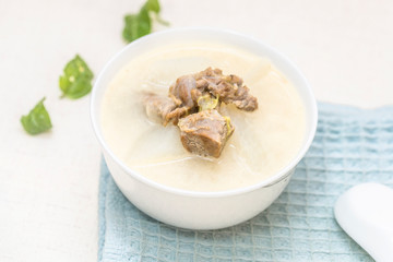 A bowl of mutton stew with radishes was set on the table