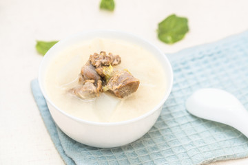 A bowl of mutton stew with radishes was set on the table