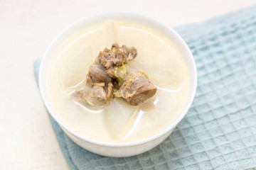 A bowl of mutton stew with radishes was set on the table