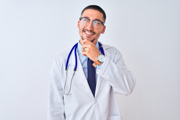 Young doctor man wearing stethoscope over isolated background with hand on chin thinking about question, pensive expression. Smiling and thoughtful face. Doubt concept.