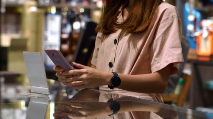 Young woman using smartphone to payment with credit transaction