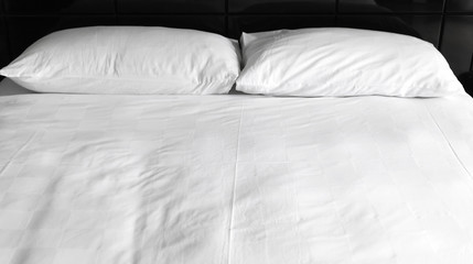 Two white pillows lay at an empty bed,