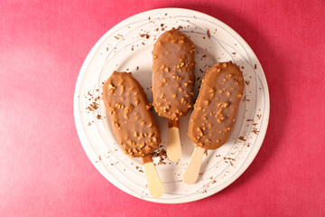 chocolate ice cream- popsicle above on red background