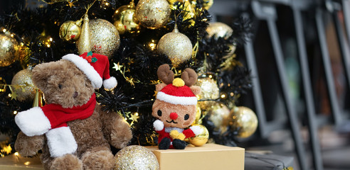 Christmas tree with cute soft toys sitting under the tree. Soft focus on the reindeer soft plush.