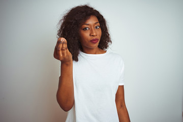 Young african american woman wearing t-shirt standing over isolated white background Doing Italian gesture with hand and fingers confident expression