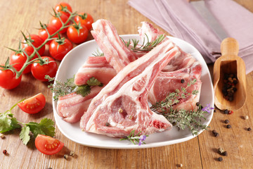 raw lamb chop and rosemary on wood background