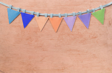 Color fabric triangle party flag on orange texture background, vintage tone style, festive season...