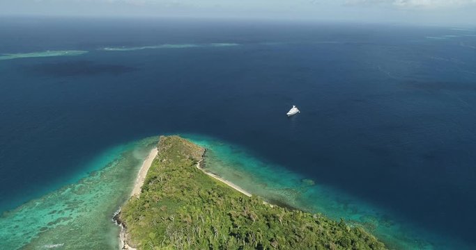 Aerial footage of ocean and land on an island in Tonga. Wide angle, vast ocean view