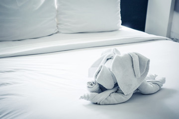 Dog shaped towel on the bed.