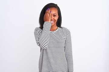 Beautiful young african american woman wearing winter sweater over isolated background covering one eye with hand, confident smile on face and surprise emotion.