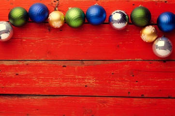 Obraz premium Red wooden background with Christmas decoration. Beautiful colored holiday element. Celebration. Merry Christmas.