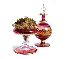 Dried Pachouli plant with vintage perfume bottle. Isolated on white background