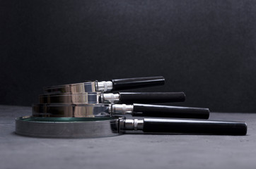 Kit of optics magnifying glasses with different power on the dark surface