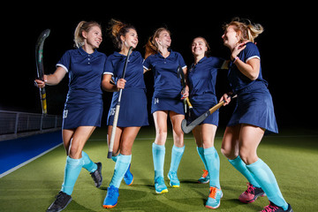 Five field hockey players celebrate the victory