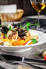 Italian food concept. Risotto with seafood, mussels, octopuses, squid. Serving dishes in a white plate. Modern serving in a restaurant. Background image. Copy space.