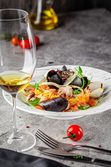 Italian food concept. Risotto with seafood, mussels, octopuses, squid. Serving dishes in a white plate. Modern serving in a restaurant. Background image. Copy space.