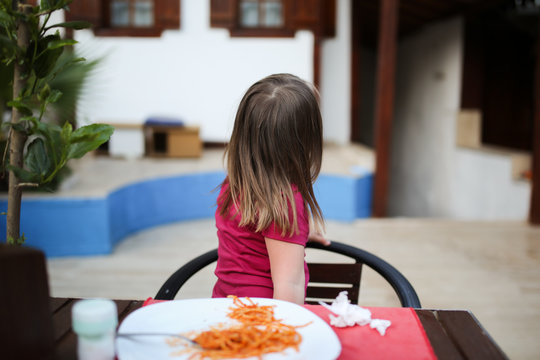 child turns away from plate with pasta