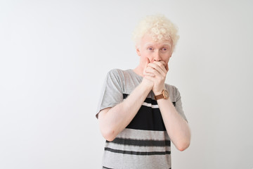 Young albino blond man wearing casual t-shirt standing over isolated white background shocked covering mouth with hands for mistake. Secret concept.
