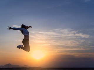 Free young woman slim body at golden sunset. Freedom and success concept,relaxing and enjoying a sunny summer holiday.