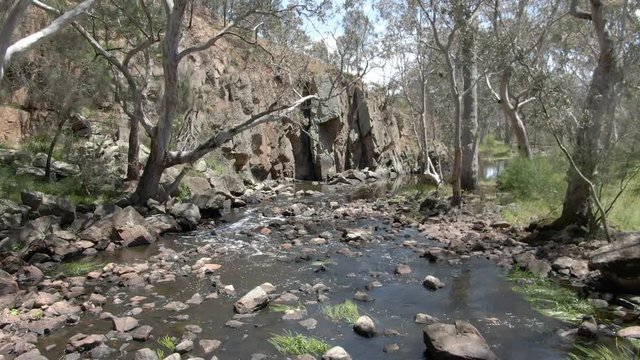 Flying above a rambling, bubbling outback rocky creek bed