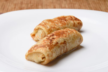Pancakes with filling on white plate