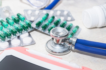 Stethoscopes on the table, empty capsules, medicines, bottles and medical supplies