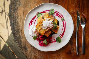 Stack of vegan pancakes decorated with banana, slice