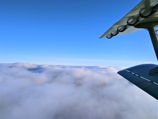 Aerial photography of winter landscape with clouds and blue sky with a biplane wing in the frame © Александр Боев