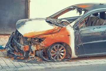 Naklejka premium Burned car, burned-out car body. Road wreck accident or arson fire burnt wheel car vehicle junk 