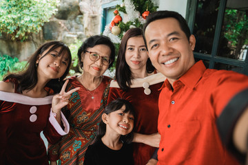 big family selfie on christmas day. asian people take picture using mobile phone