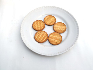 fresh healthy wheat biscuits put in a plate isolated on white background