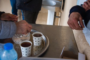 Fototapeta na wymiar Istanbul/Turkey - 12.01.2019: Drinking turkish tea in small cheap place. hands of men