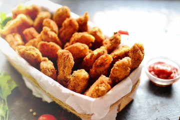 Chicken nuggets with a crispy crust. Delicious chicken meat on a wooden background. Fried meat, breast. 