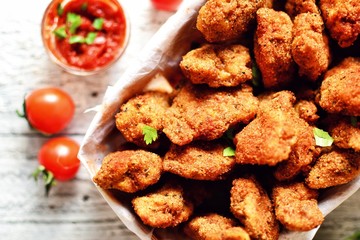 Chicken nuggets with a crispy crust. Delicious chicken meat on a wooden background. Fried meat, breast. 